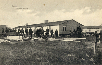 10814 Gezicht op twee militaire barakken te Jutphaas; met een groep militairen, bezig met het maken van een houten ...